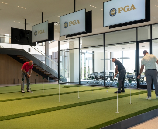 people practicing on Tour Greens indoor putting greens in PGA of America Headquarters