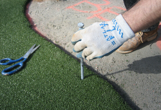 a professional installer working on the edge of newly laid turf